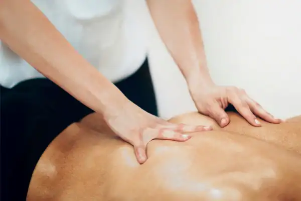 Person receiving a back massage therapy session.